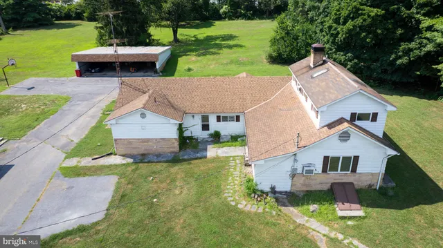 a aerial view of a house with a yard table and chairs