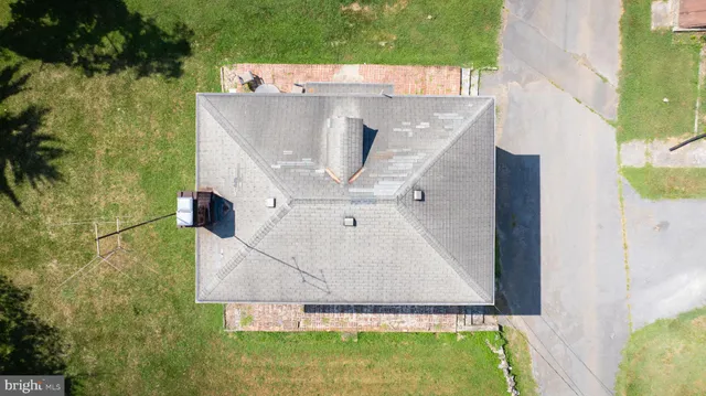 an aerial view of grey house with outdoor space