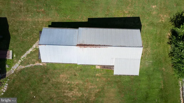 an aerial view of residential houses with outdoor space and trees all around