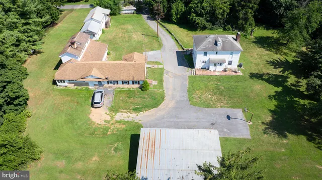 an aerial view of residential house with outdoor space and trees all around