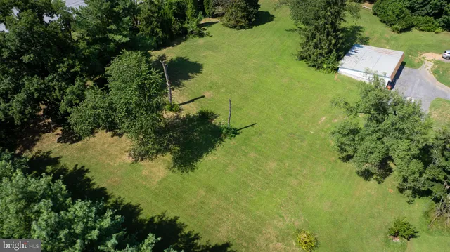an aerial view of residential house with outdoor space and trees all around