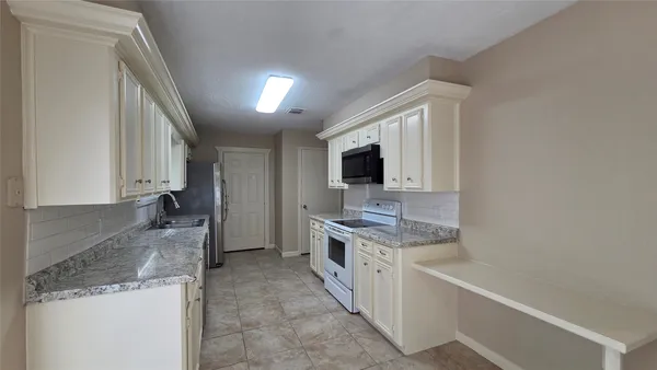 a kitchen with stainless steel appliances granite countertop a sink stove and microwave
