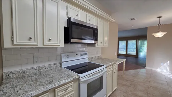 a kitchen with granite countertop a stove and a sink