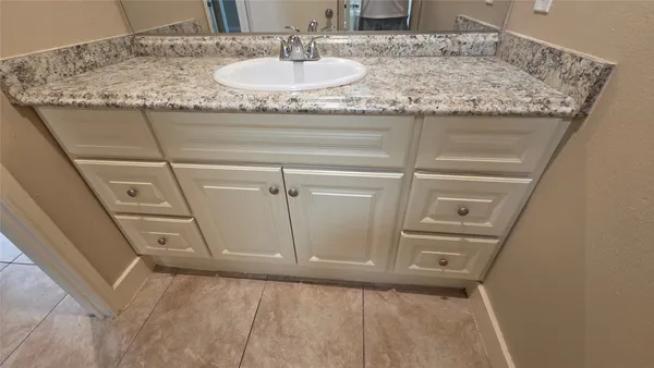 a bathroom with a granite countertop sink and a mirror