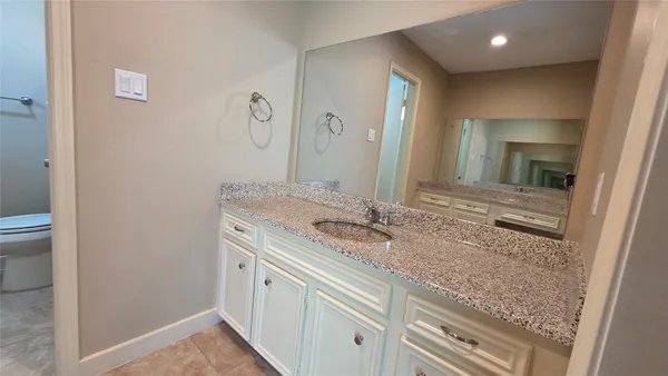a bathroom with a granite countertop sink and a mirror