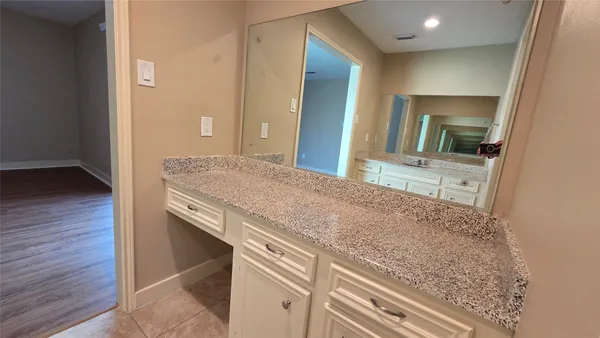 a en suite bathroom with a granite countertop sink and a mirror