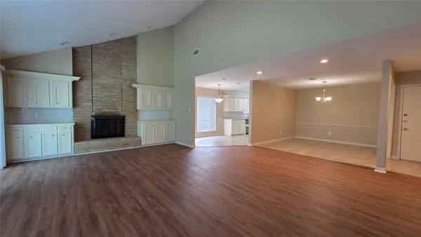 a view of a big room with wooden floor and fire place
