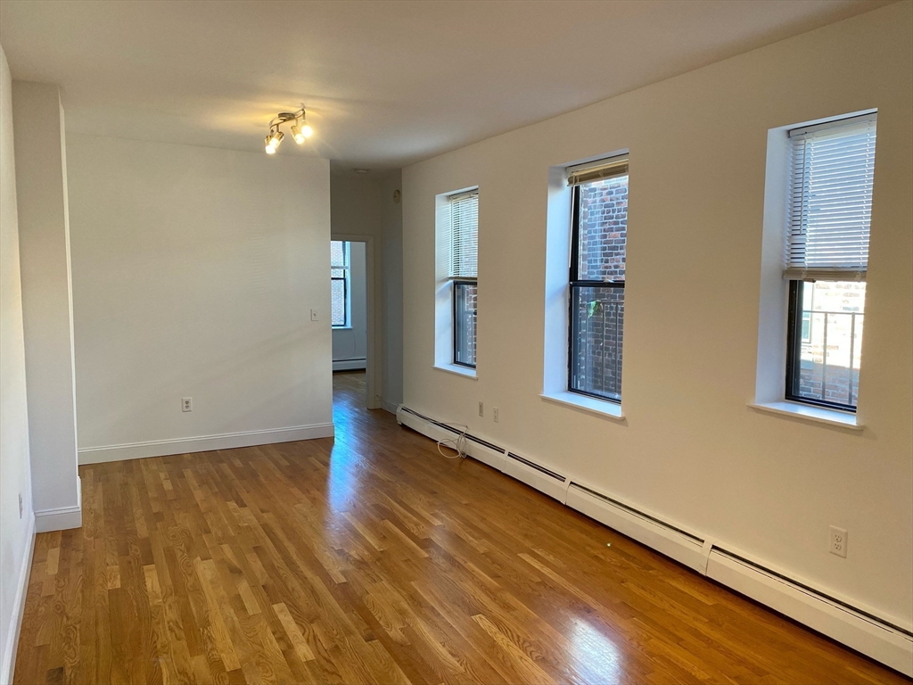 225-227 East Berkeley Street, Unit 4 Boston, MA 02118 - Photo 2 of 10 a view of an empty room with window and wooden floor