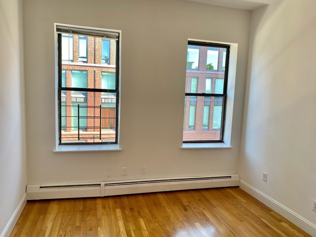225-227 East Berkeley Street, Unit 4 Boston, MA 02118 - Photo 8 of 10 a view of an empty room with wooden floor and a window