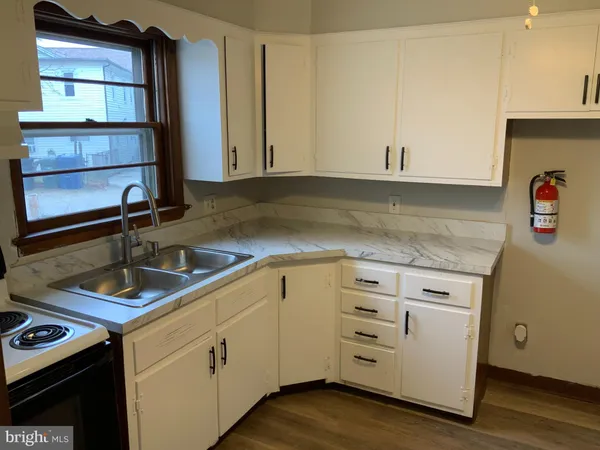 a kitchen with a stove and a wooden floor