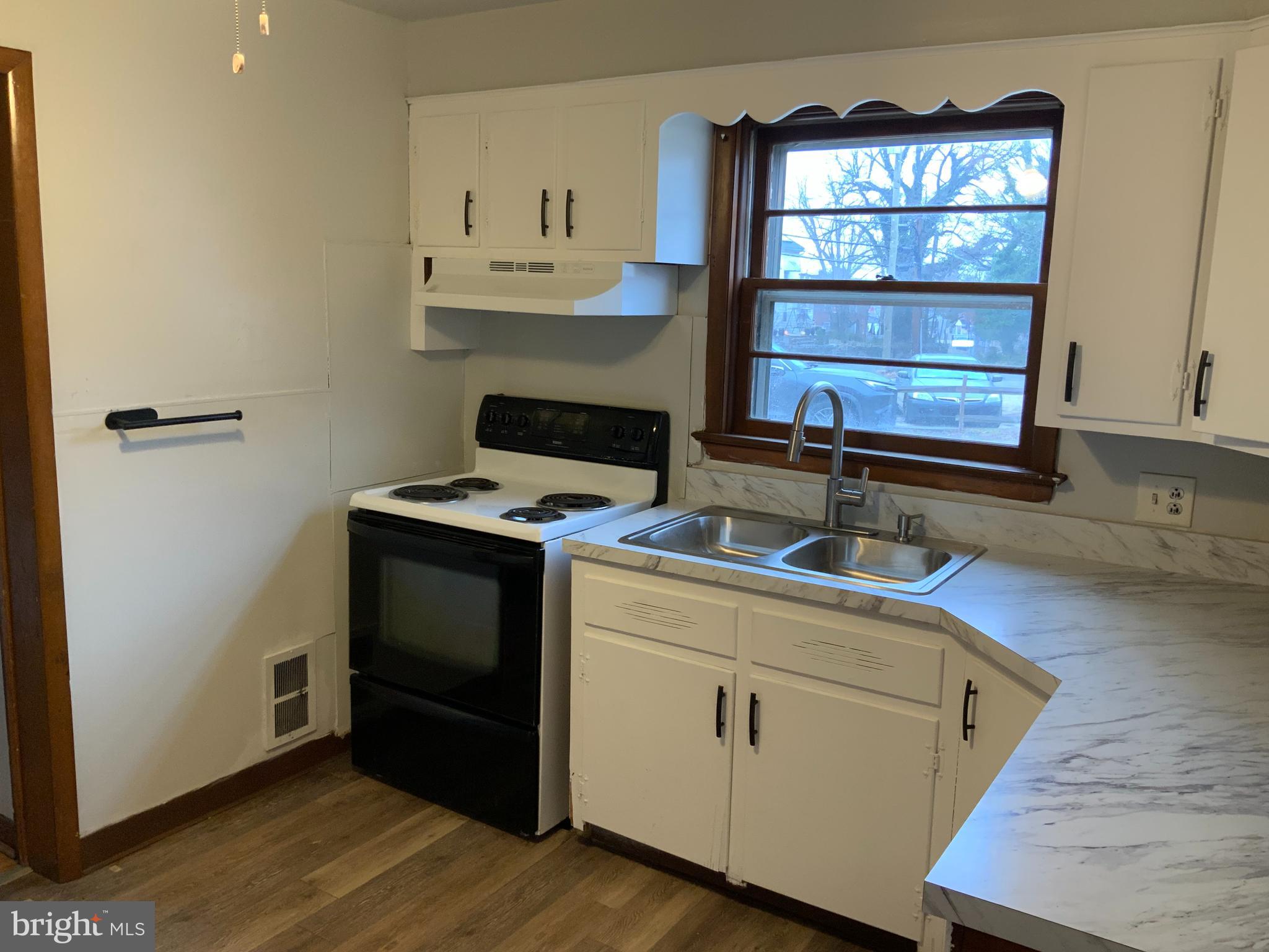 334 Blue Bell Road Williamstown, NJ 08094 - Photo 9 of 18 a kitchen with a stove and a wooden floor