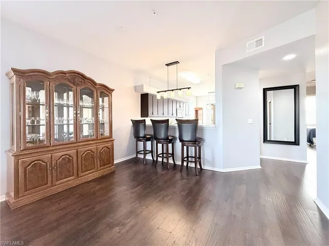 a view of a livingroom with furniture hardwood floor and a view of kitchen