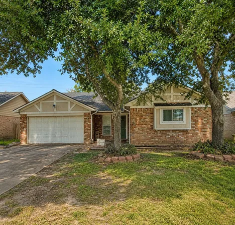 a front view of house with yard and trees in the background
