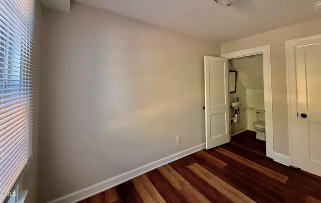 a view of a room with wooden floor and a hallway