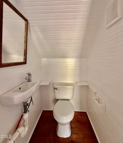 a bathroom with a toilet a sink and mirror