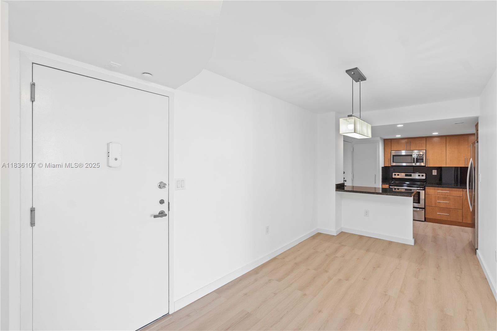 2333 Brickell Avenue, Unit 1908 Miami, FL 33129 - Photo 3 of 29 a kitchen with a refrigerator and white cabinets