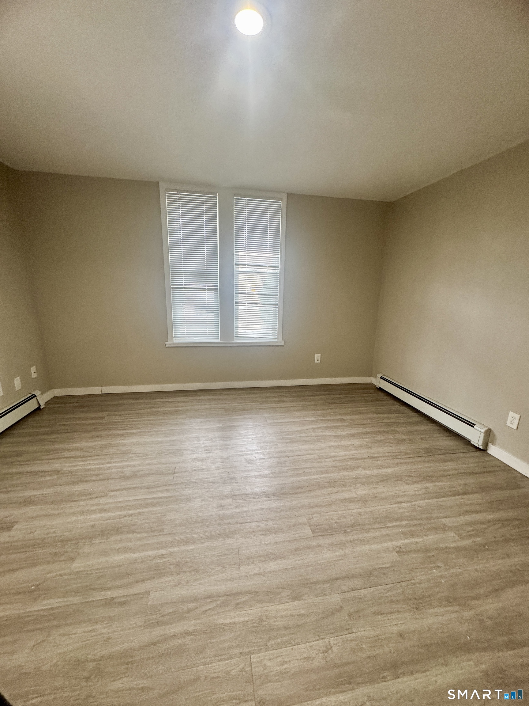 124 Meriden Road Waterbury, CT 06705 - Photo 3 of 5 wooden floor in an empty room with a window
