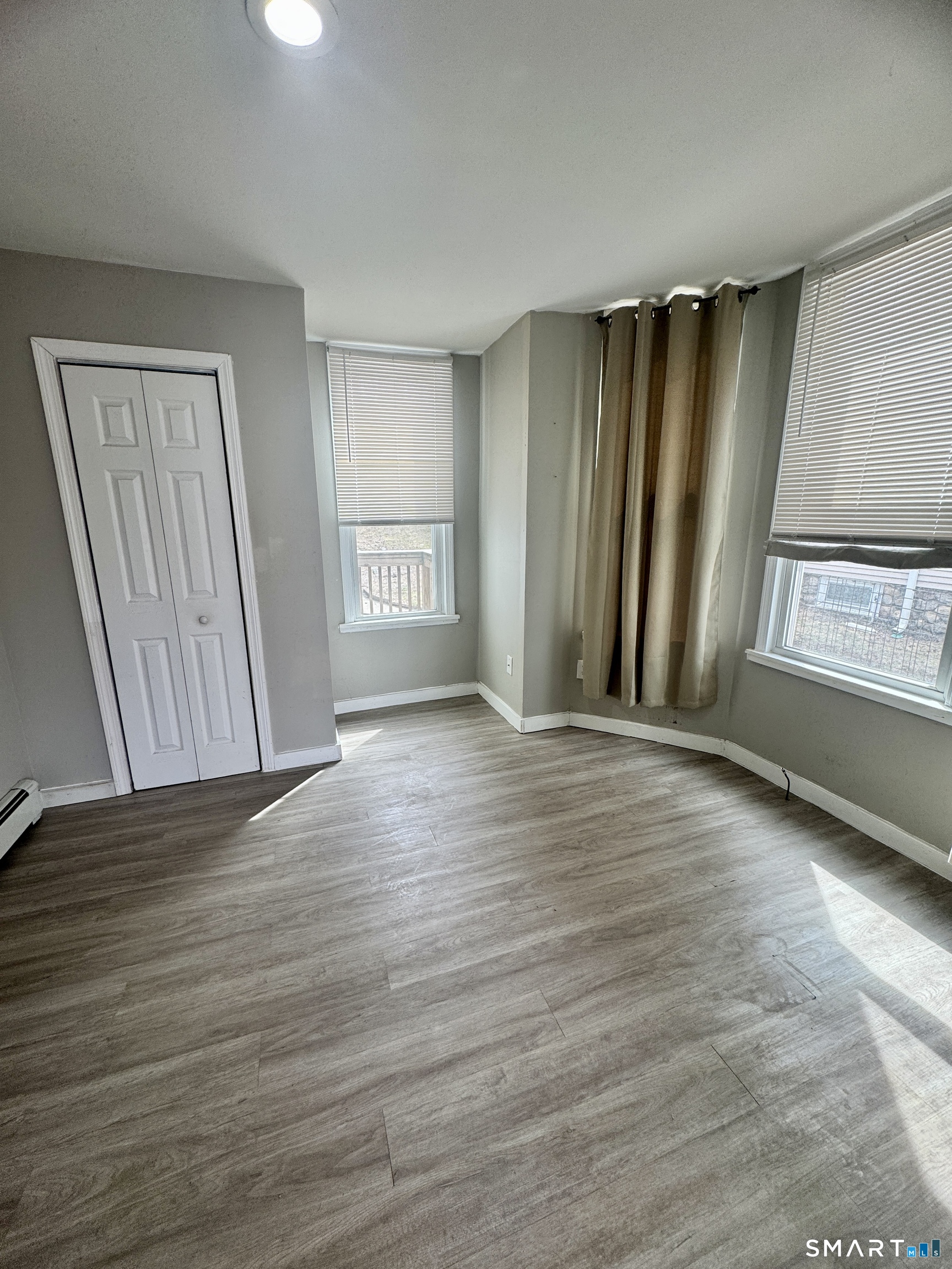 124 Meriden Road Waterbury, CT 06705 - Photo 5 of 5 an empty room with wooden floor and windows