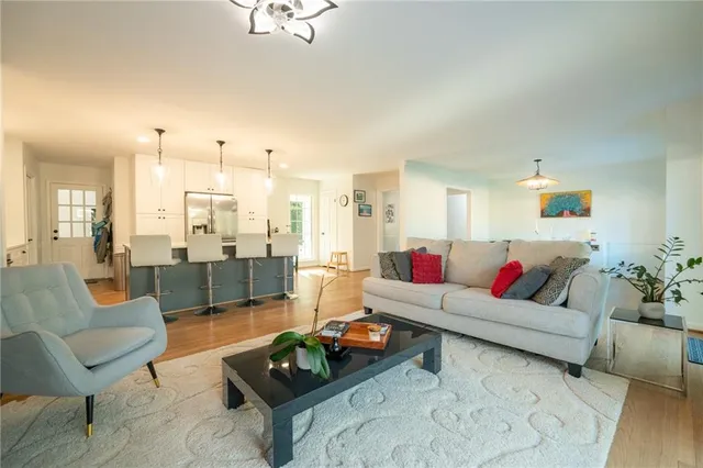 a living room with furniture and a view of kitchen