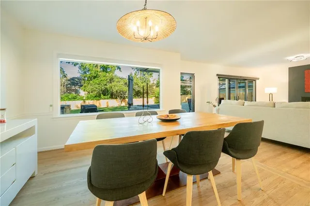 a dining room with wooden floor and large windows
