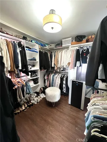 a view of walk in closet with clothes and shoes