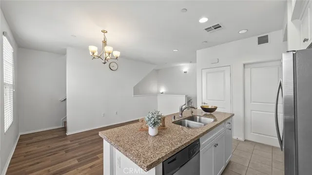 a kitchen with stainless steel appliances granite countertop a sink refrigerator and cabinets