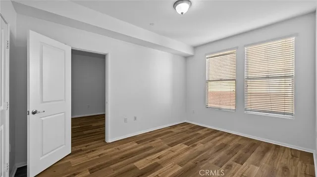 an empty room with wooden floor and window