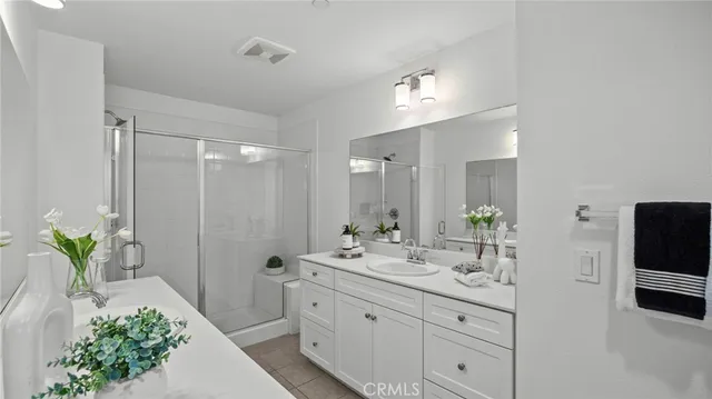 a bathroom with a double vanity sink and shower