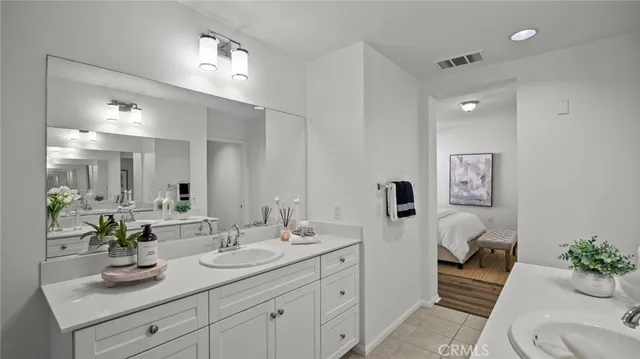 a bathroom with a sink double vanity mirror and toilet