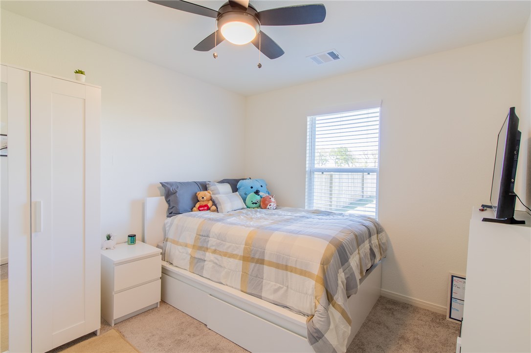 6029 Toby Bend Bryan, TX 77807 - Photo 12 of 25 a bedroom with a bed and a flat tv screen on dresser