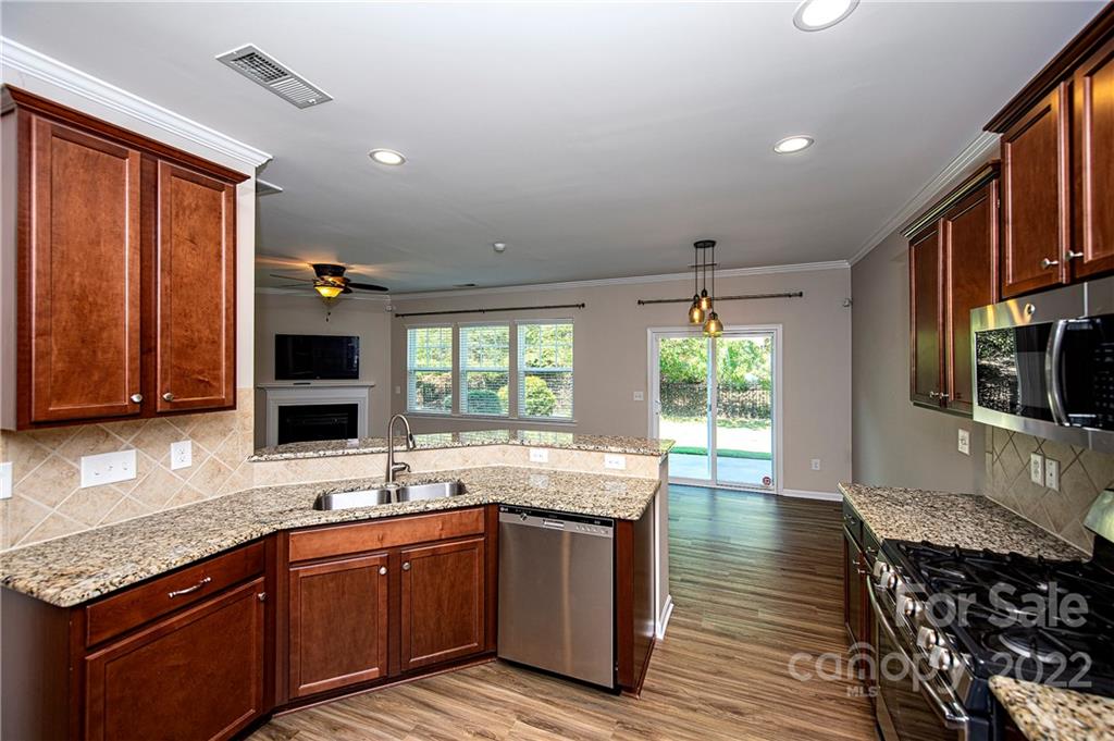 249 Catoctin Road Rock Hill, SC 29732 - Photo 4 of 30 a kitchen with stainless steel appliances granite countertop a sink stove and wooden cabinets