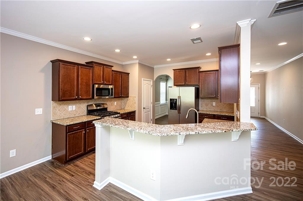 249 Catoctin Road Rock Hill, SC 29732 - Photo 5 of 30 a kitchen with stainless steel appliances granite countertop a refrigerator a sink a stove a microwave and island with wooden floor