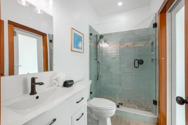 a bathroom with a sink a toilet and shower