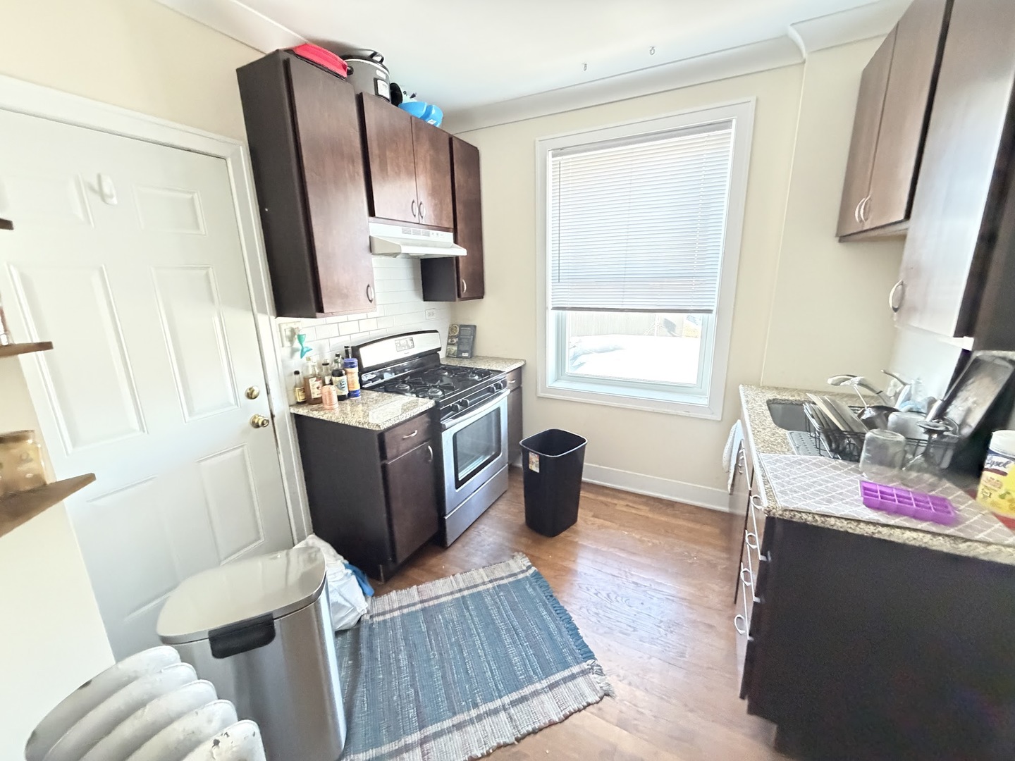 3153 West Augusta Boulevard, Unit 3B Chicago, IL 60622 - Photo 2 of 12 a kitchen with stainless steel appliances granite countertop a stove a sink and a microwave