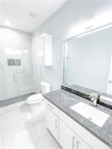 a bathroom with a toilet a sink and shower