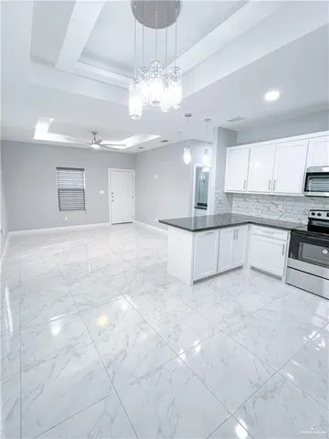 a kitchen with granite countertop a refrigerator sink and microwave