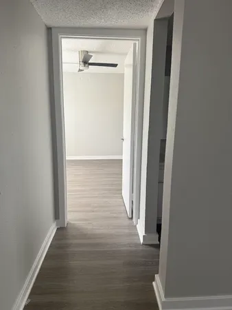 a view of a hallway with wooden floor