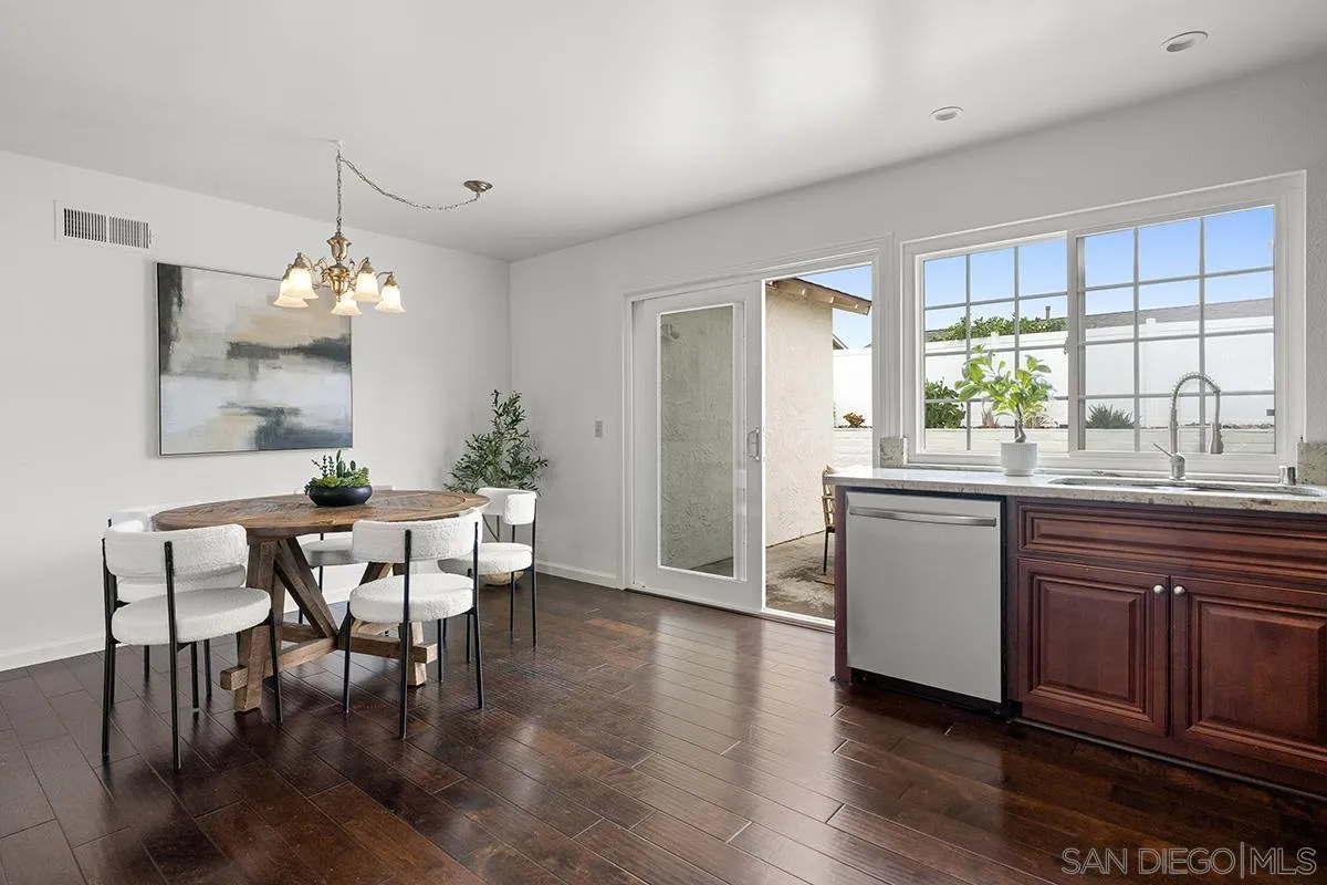 11394 Pegasus Avenue San Diego, CA 92126 - Photo 15 of 46 a dining room with wooden floor a chandelier a wooden table and chairs