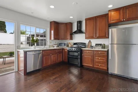 a kitchen with stainless steel appliances granite countertop a stove a sink and a white cabinets