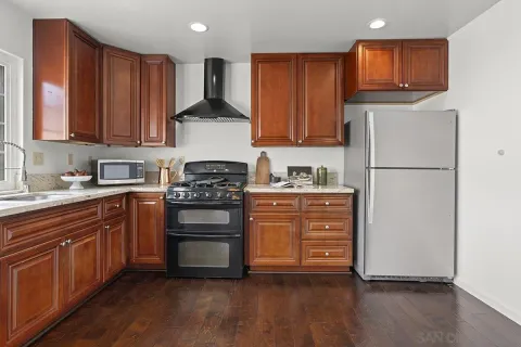 a kitchen with a refrigerator and a stove top oven