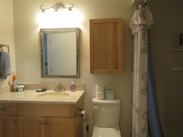 a bathroom with a sink vanity granite and toilet