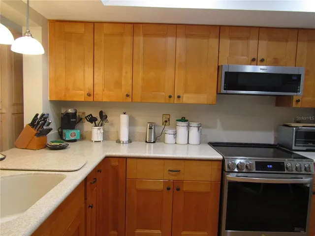 a kitchen with a sink a stove and cabinets