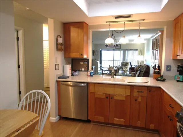 a kitchen with stainless steel appliances granite countertop a sink and wooden cabinets