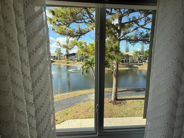 a bathroom with a window and a white cabinet
