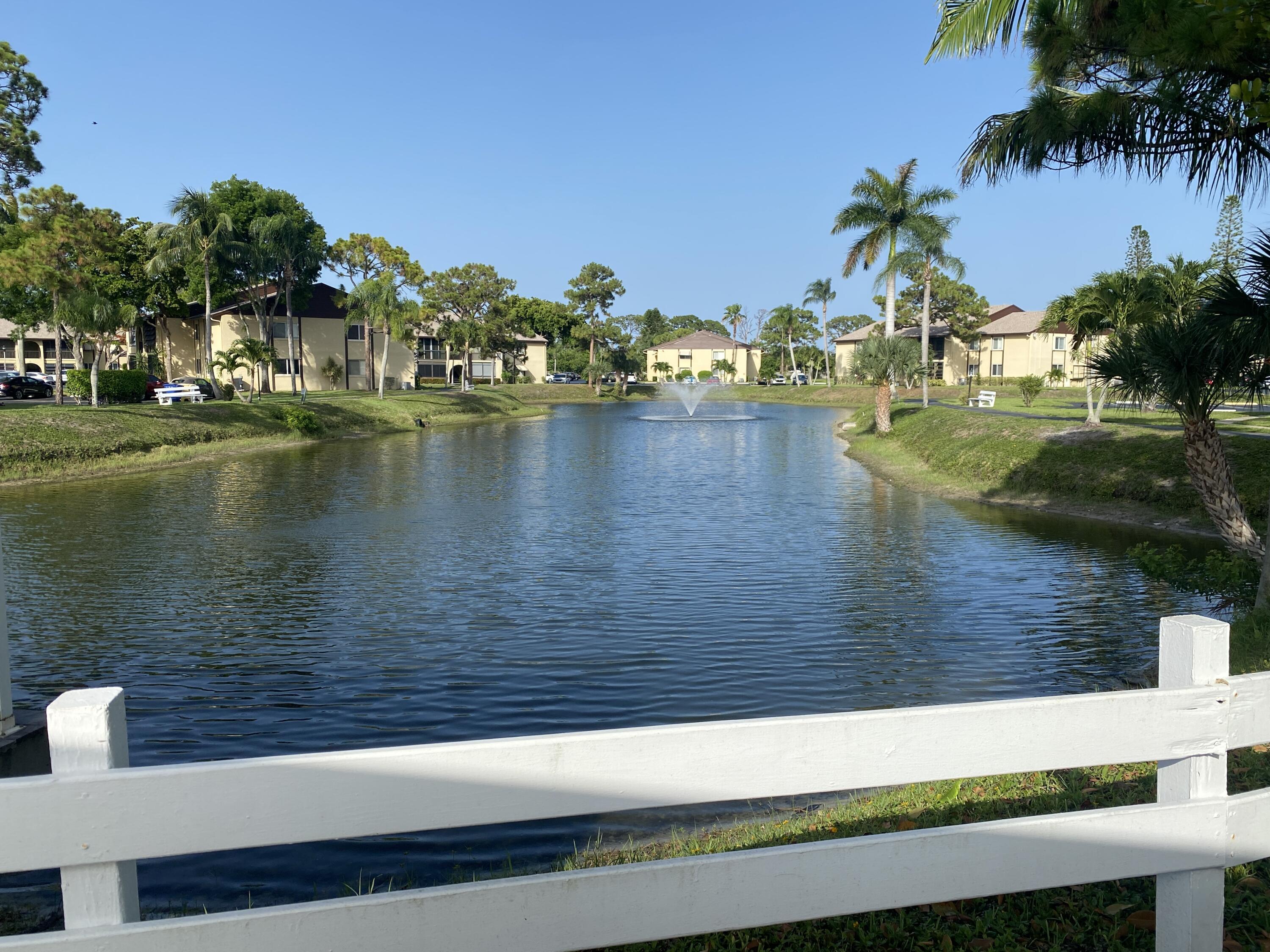 338 Pine Ridge Circle, Unit B2 Greenacres, FL 33463 - Photo 49 of 56 a view of a lake with houses