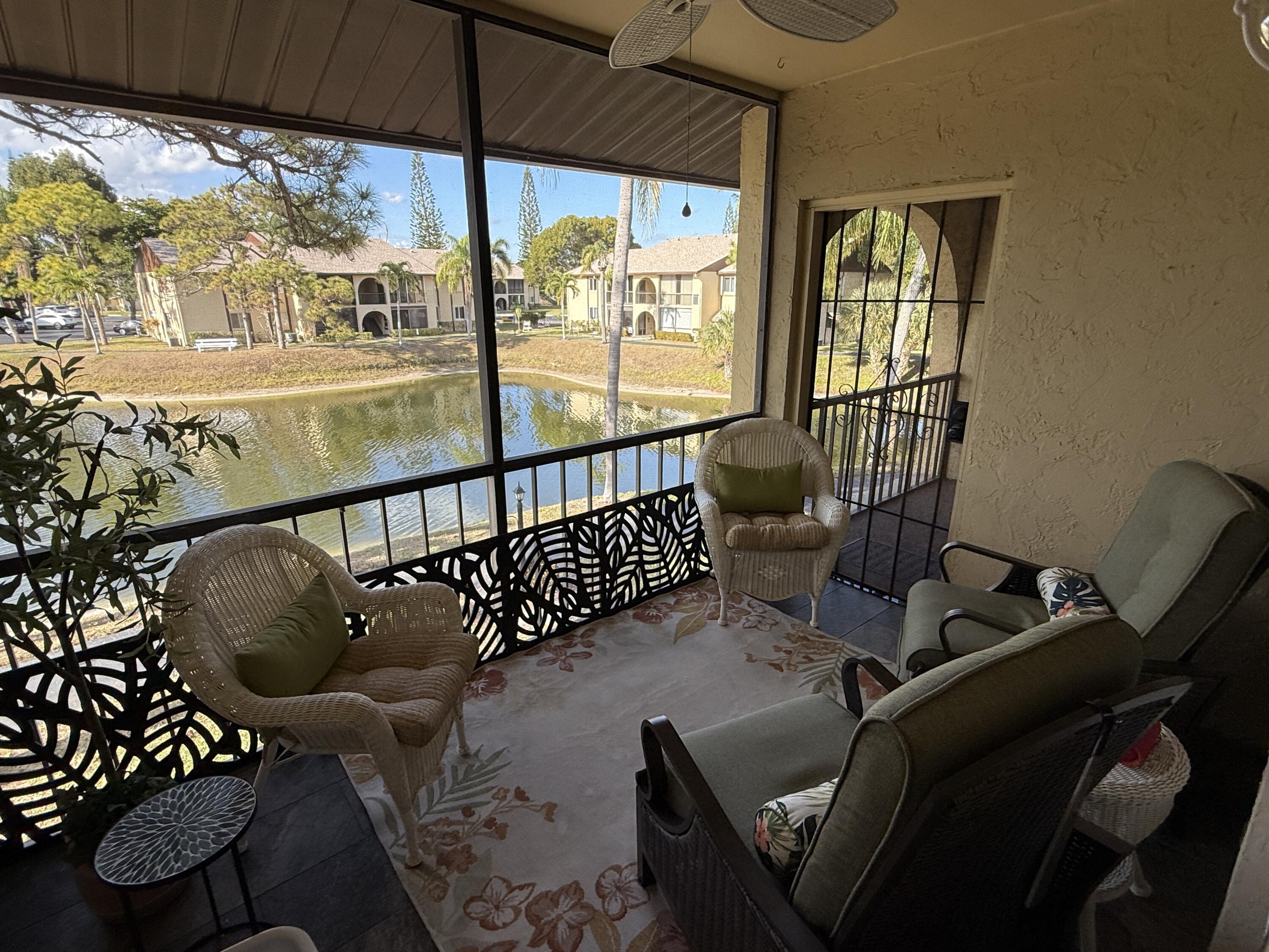 338 Pine Ridge Circle, Unit B2 Greenacres, FL 33463 - Photo 10 of 56 a view of a porch with furniture and floor to ceiling window