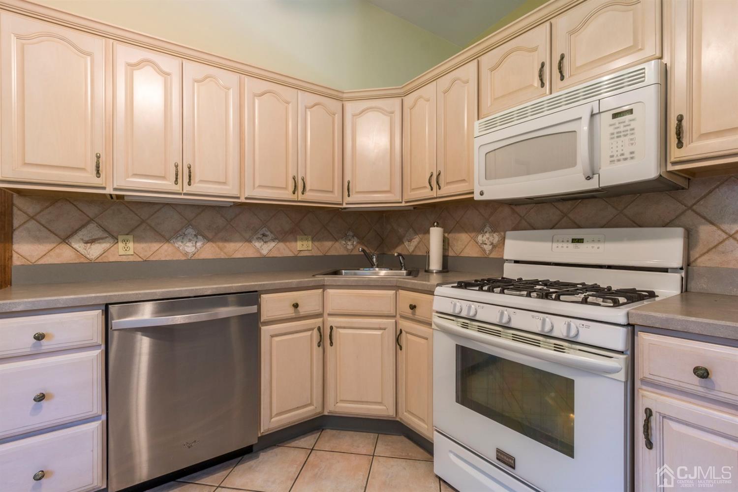 27 Mill Road Edison, NJ 08817 - Photo 11 of 31 a kitchen with granite countertop white cabinets and stainless steel appliances