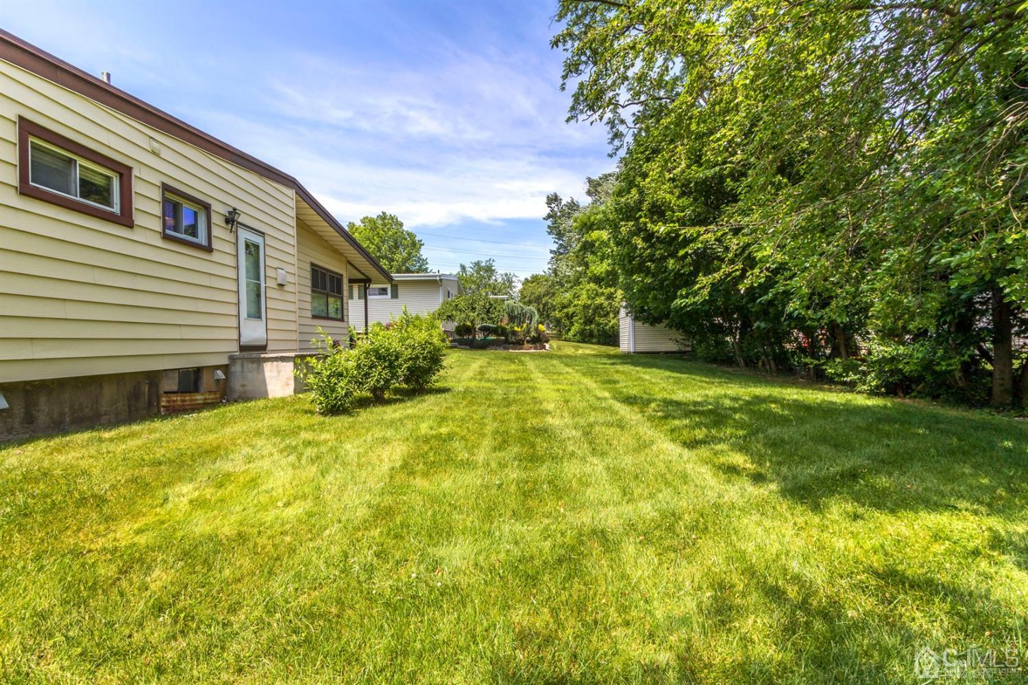 27 Mill Road Edison, NJ 08817 - Photo 29 of 31 a view of a backyard with plants and large trees