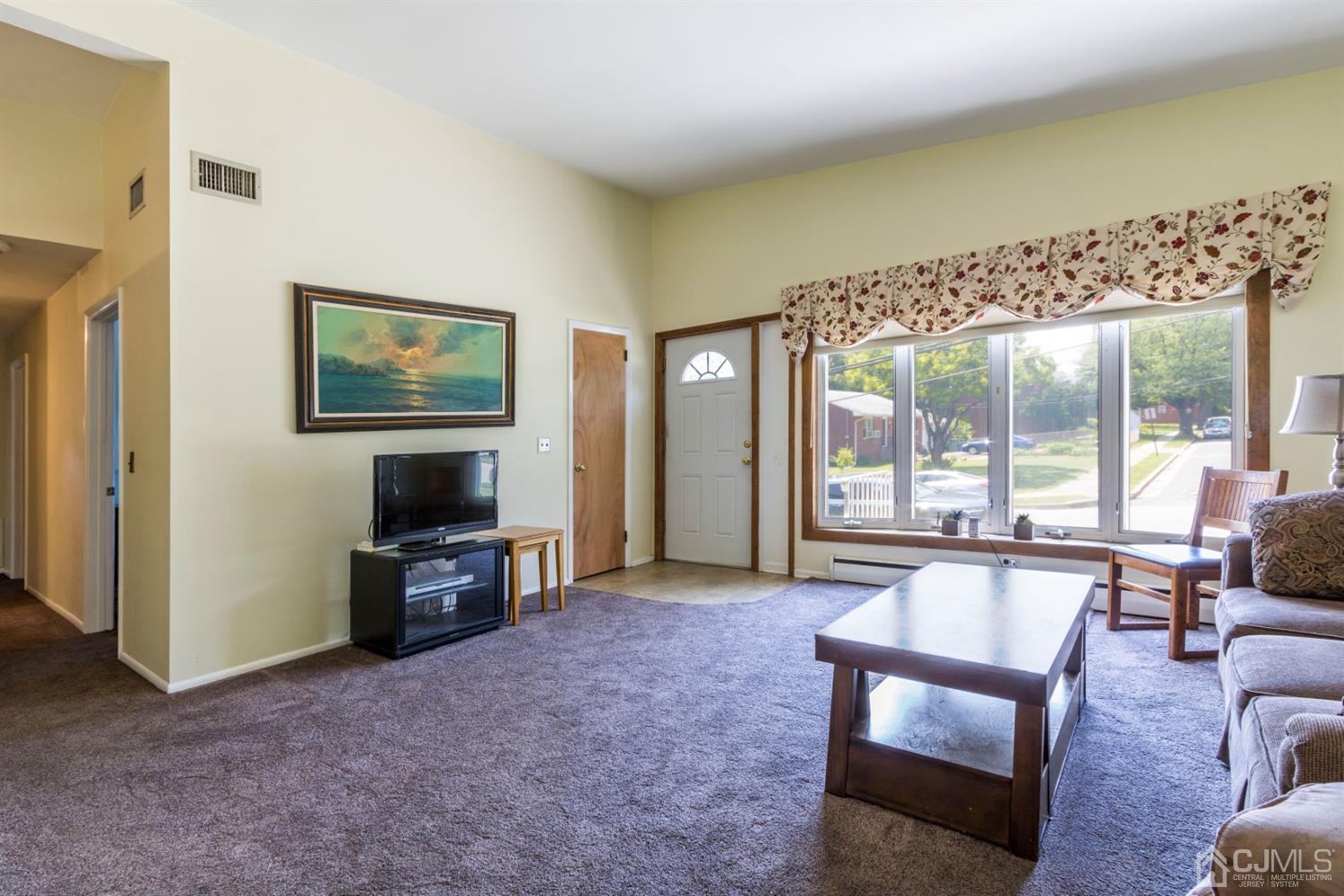 27 Mill Road Edison, NJ 08817 - Photo 5 of 31 a living room with furniture a large window and a flat screen tv