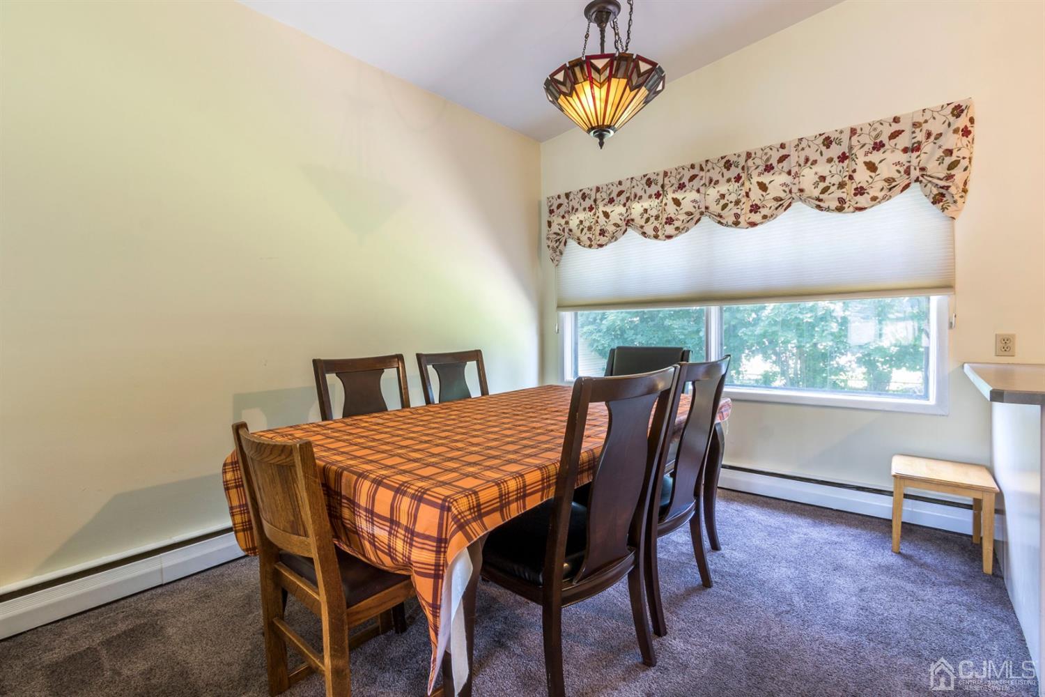 27 Mill Road Edison, NJ 08817 - Photo 8 of 31 a dining room with a wooden table and chairs